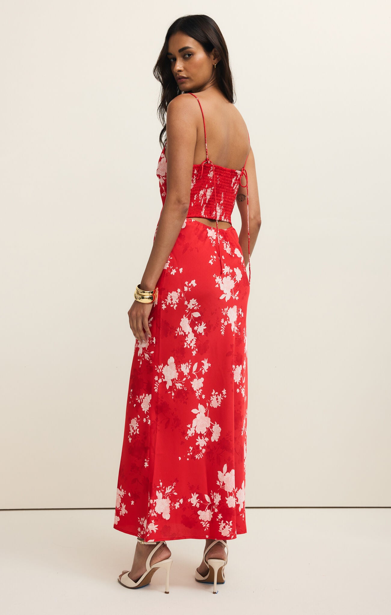 Woman wearing a red floral dress against a white background