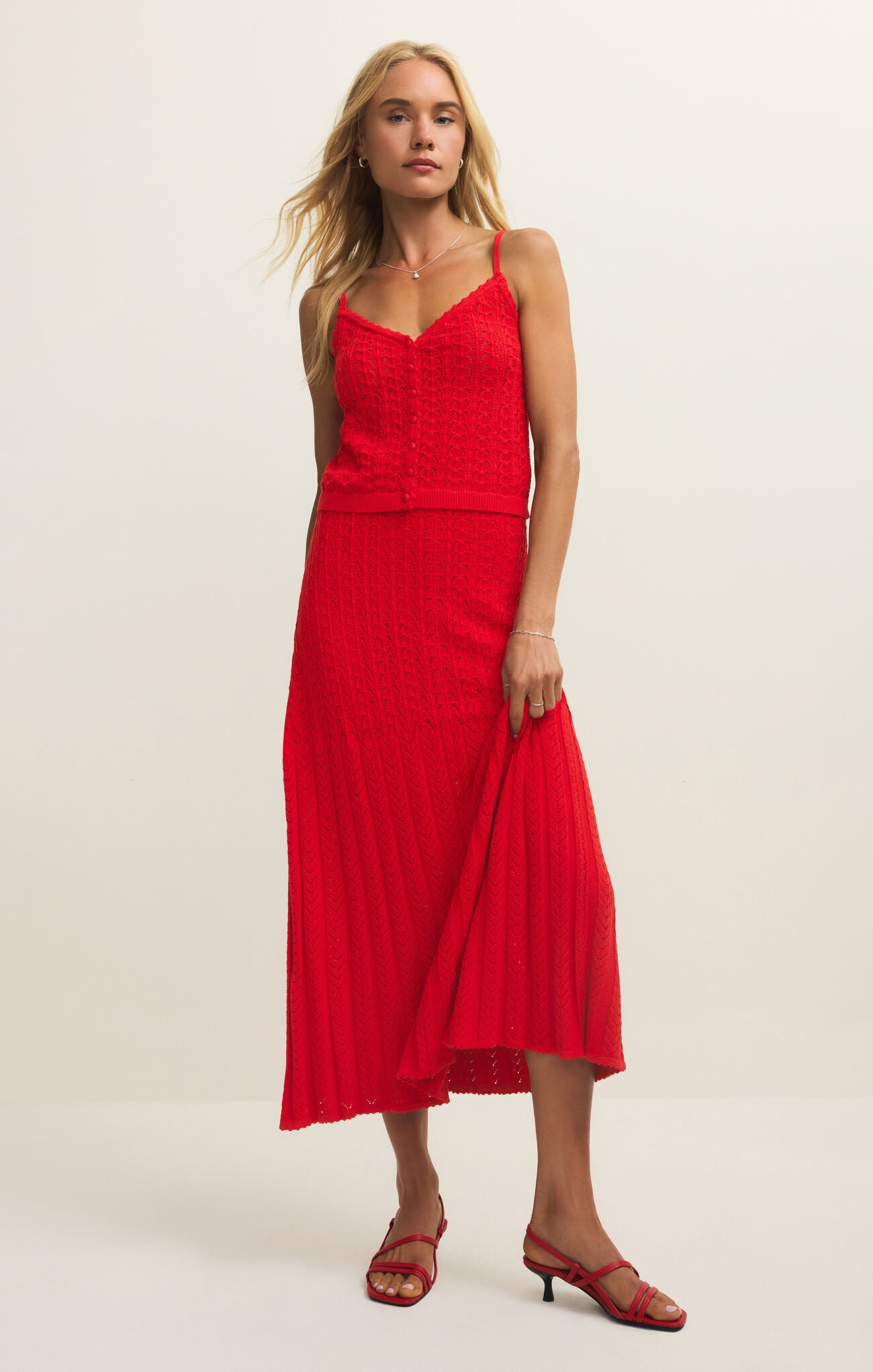 Woman wearing a red dress on a beige background