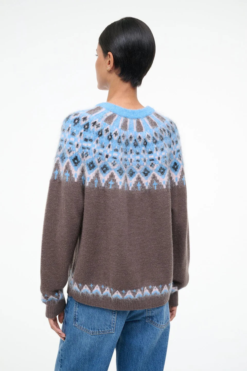 Person wearing a brown and blue patterned sweater on a white background