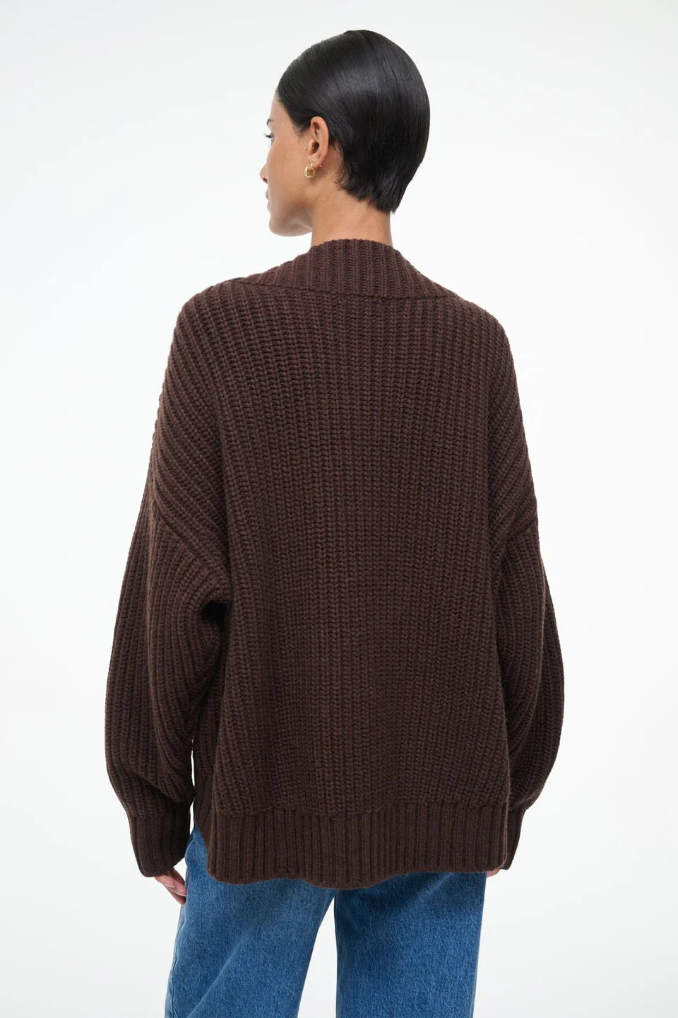 Person wearing a brown knitted cardigan on a white background