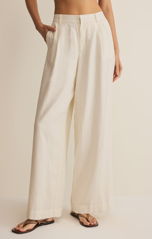 Person wearing beige wide-leg pants on a plain background