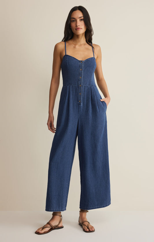 Woman wearing a blue jumpsuit on a beige background