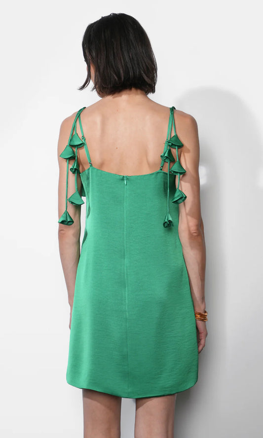 Green dress with ruffled straps worn by a person on a white background