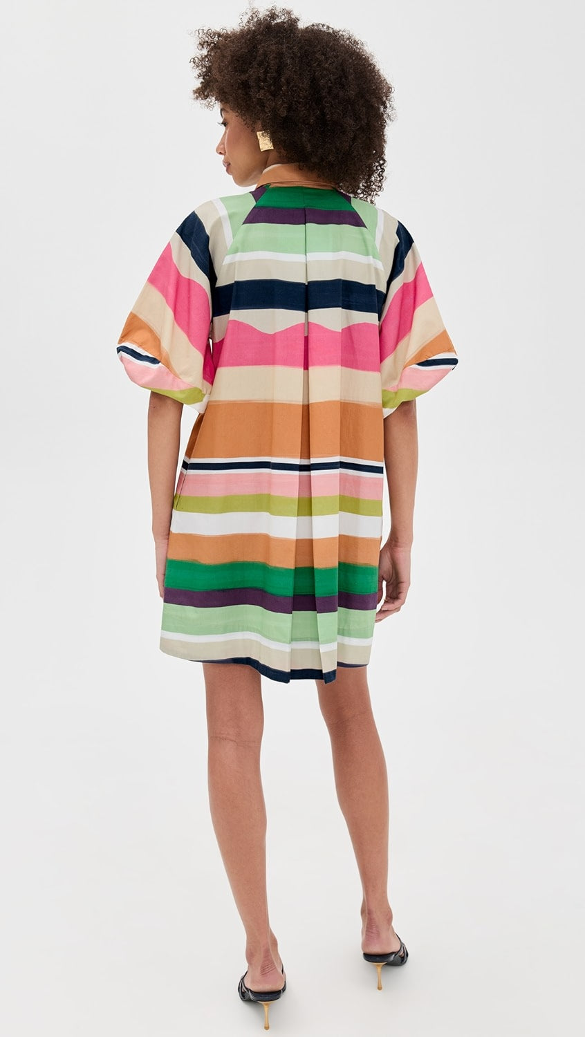 Woman wearing a colorful striped dress on a white background