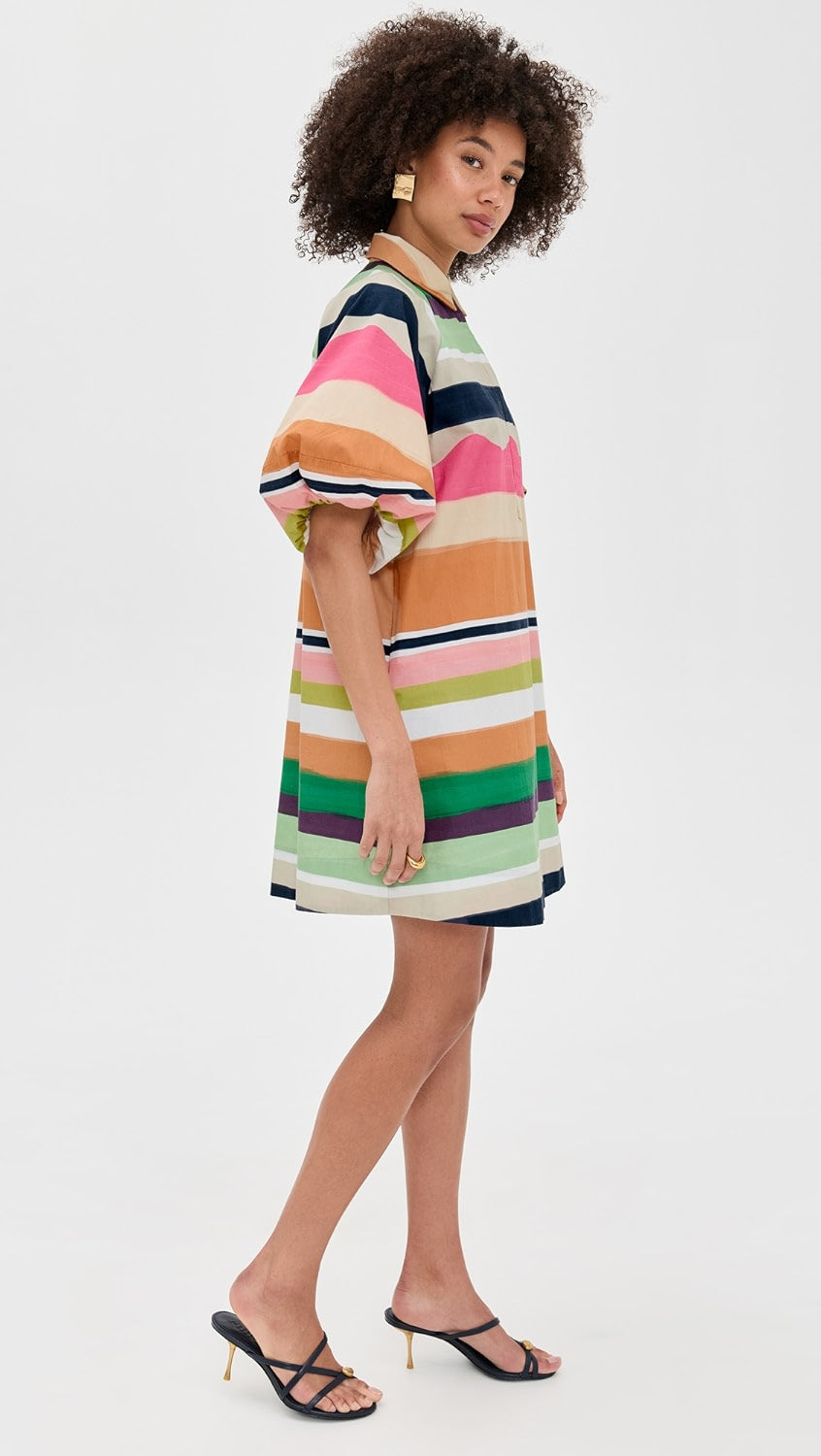 Woman wearing a colorful striped dress on a white background