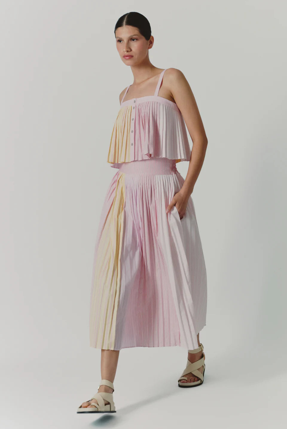 Woman wearing a pastel striped dress on a white background