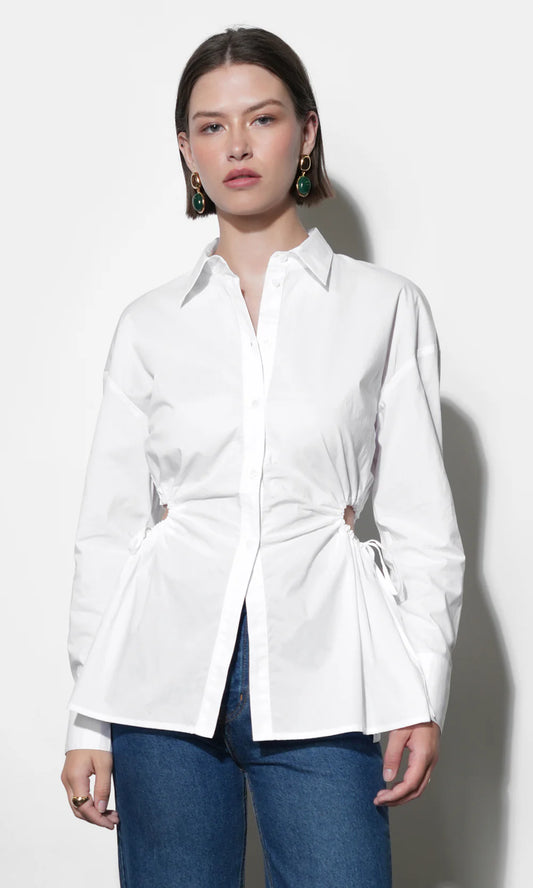 Woman wearing a white shirt with a tie-waist design against a white background