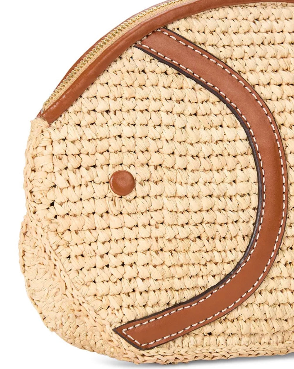Round woven bag with brown leather strap on a white background