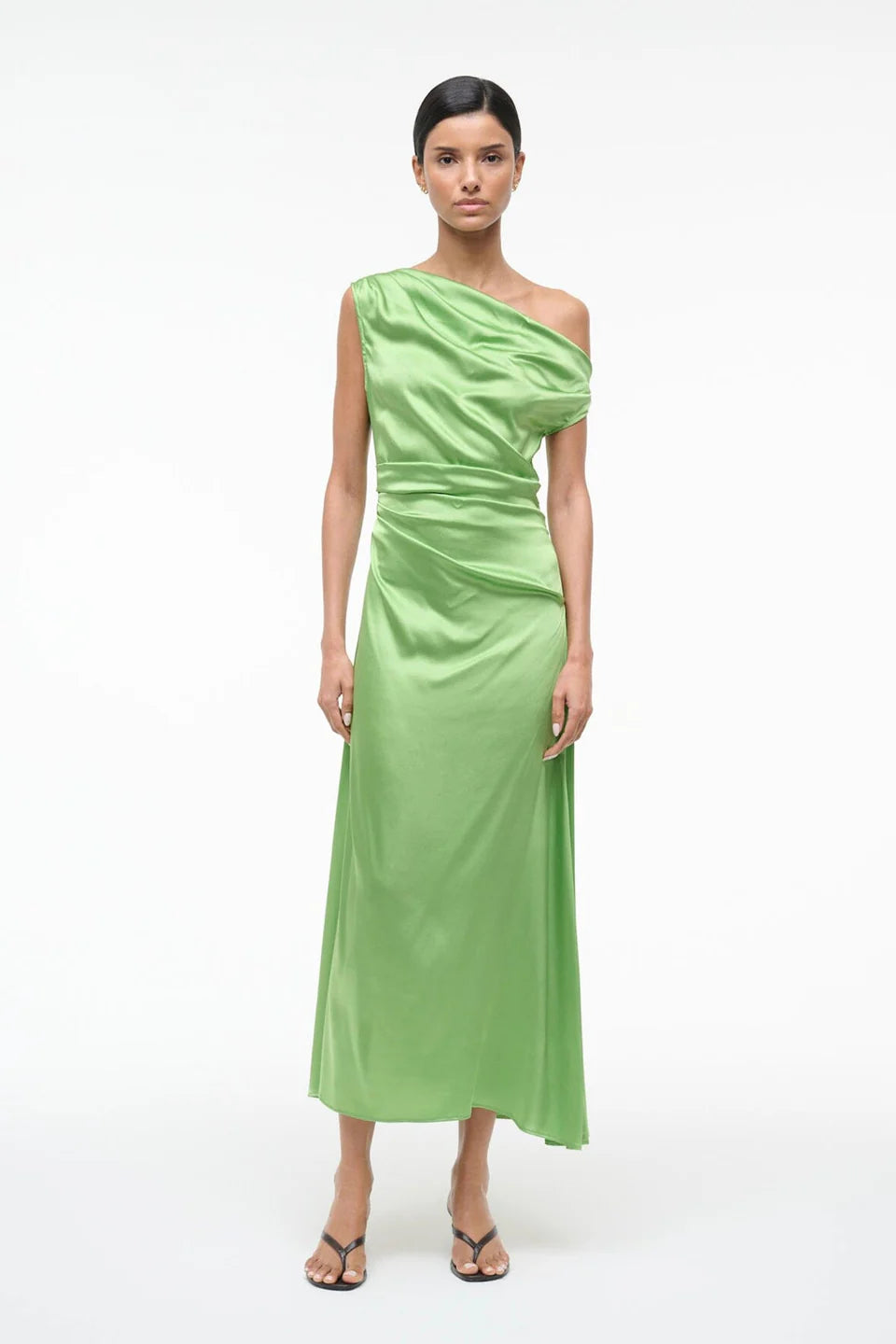 Woman wearing a green one-shoulder dress on a white background