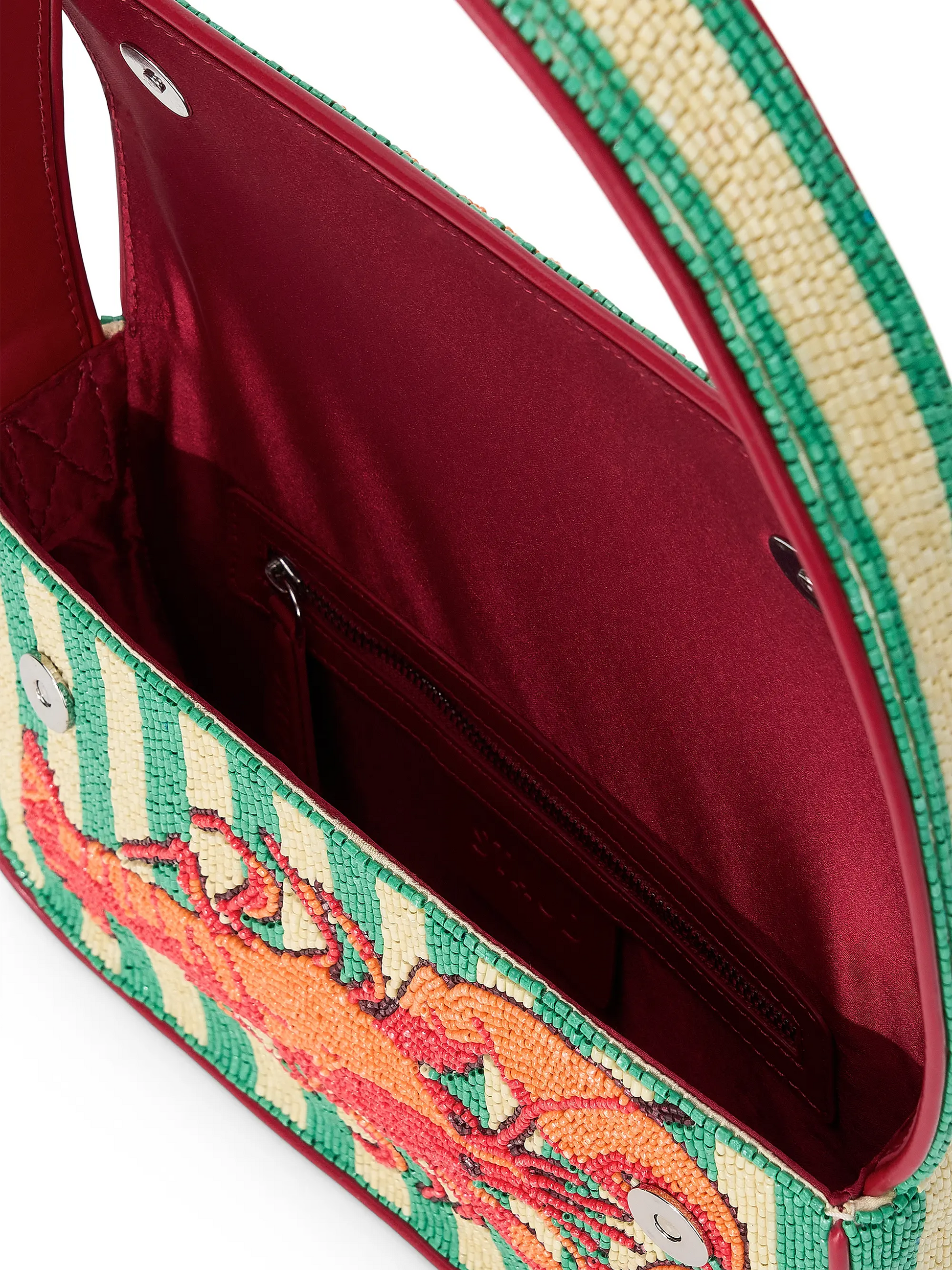 Close-up of a handbag with colorful design and red interior