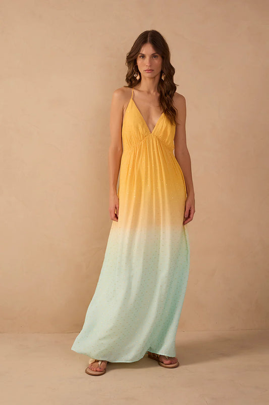 Woman wearing a yellow to green gradient dress against a beige background