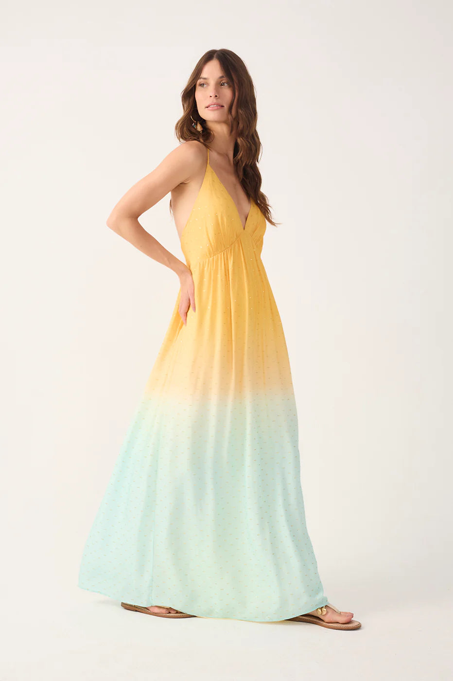 Woman wearing a yellow to light blue gradient dress on a white background