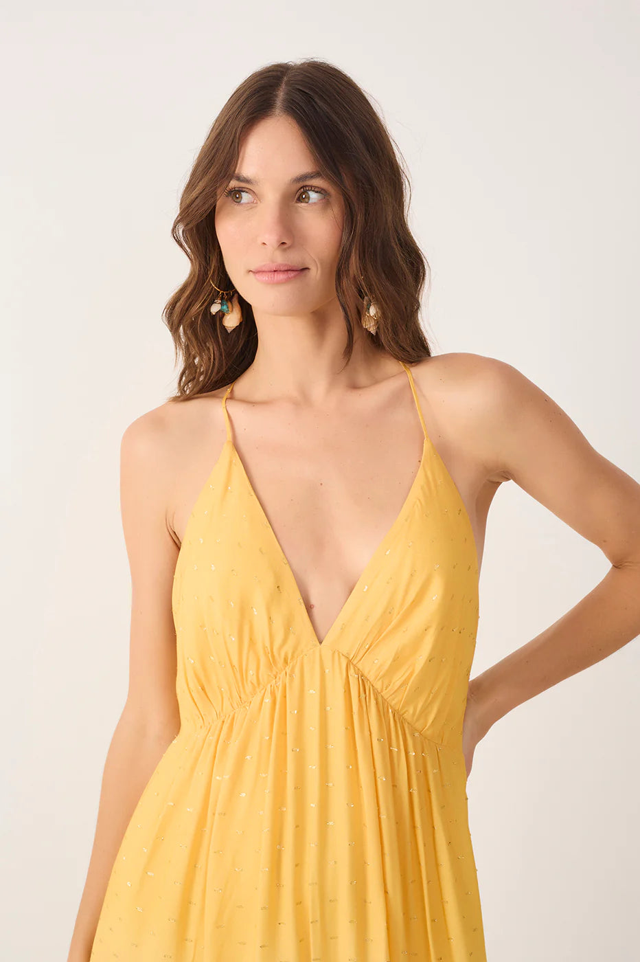 Woman wearing a yellow dress against a white background