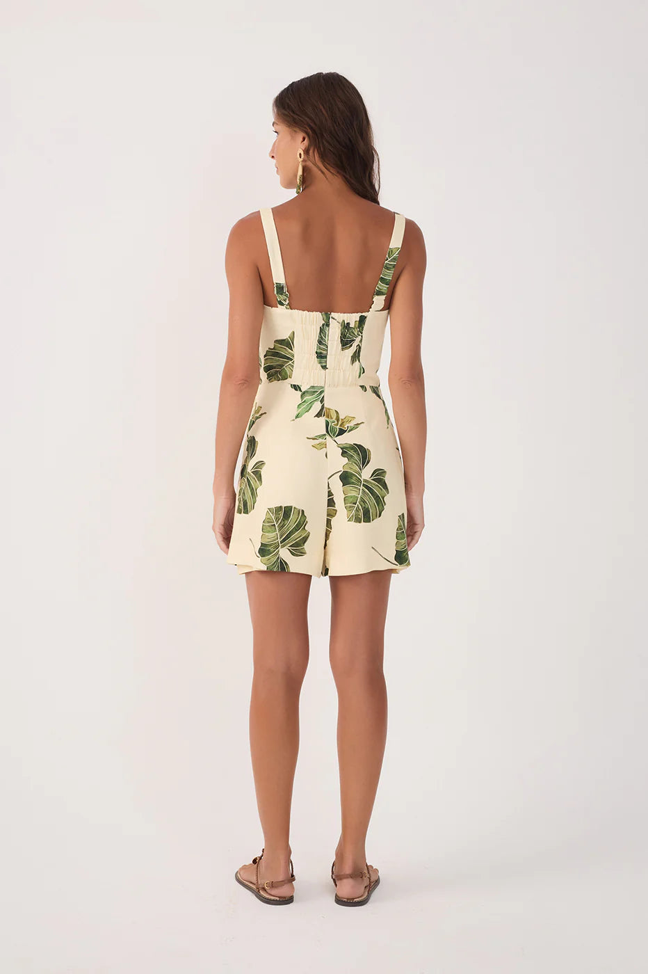 Woman wearing a leaf-patterned dress on a white background