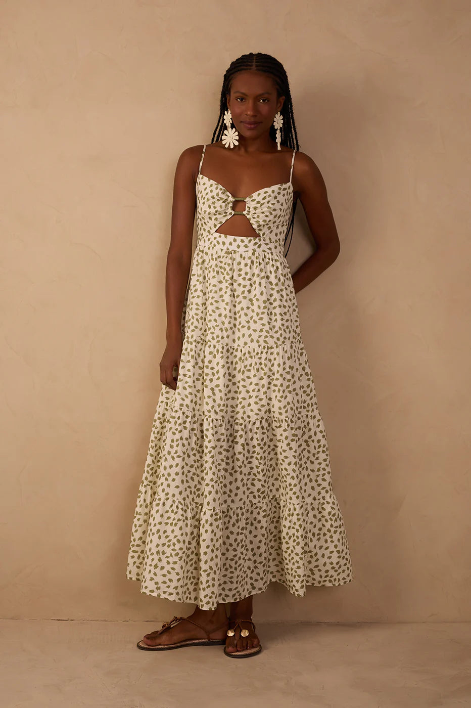 Woman wearing a white floral dress against a beige background
