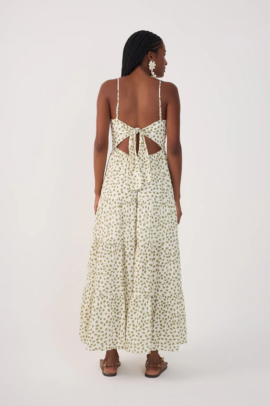 Woman wearing a floral dress with cut-out back on a white background