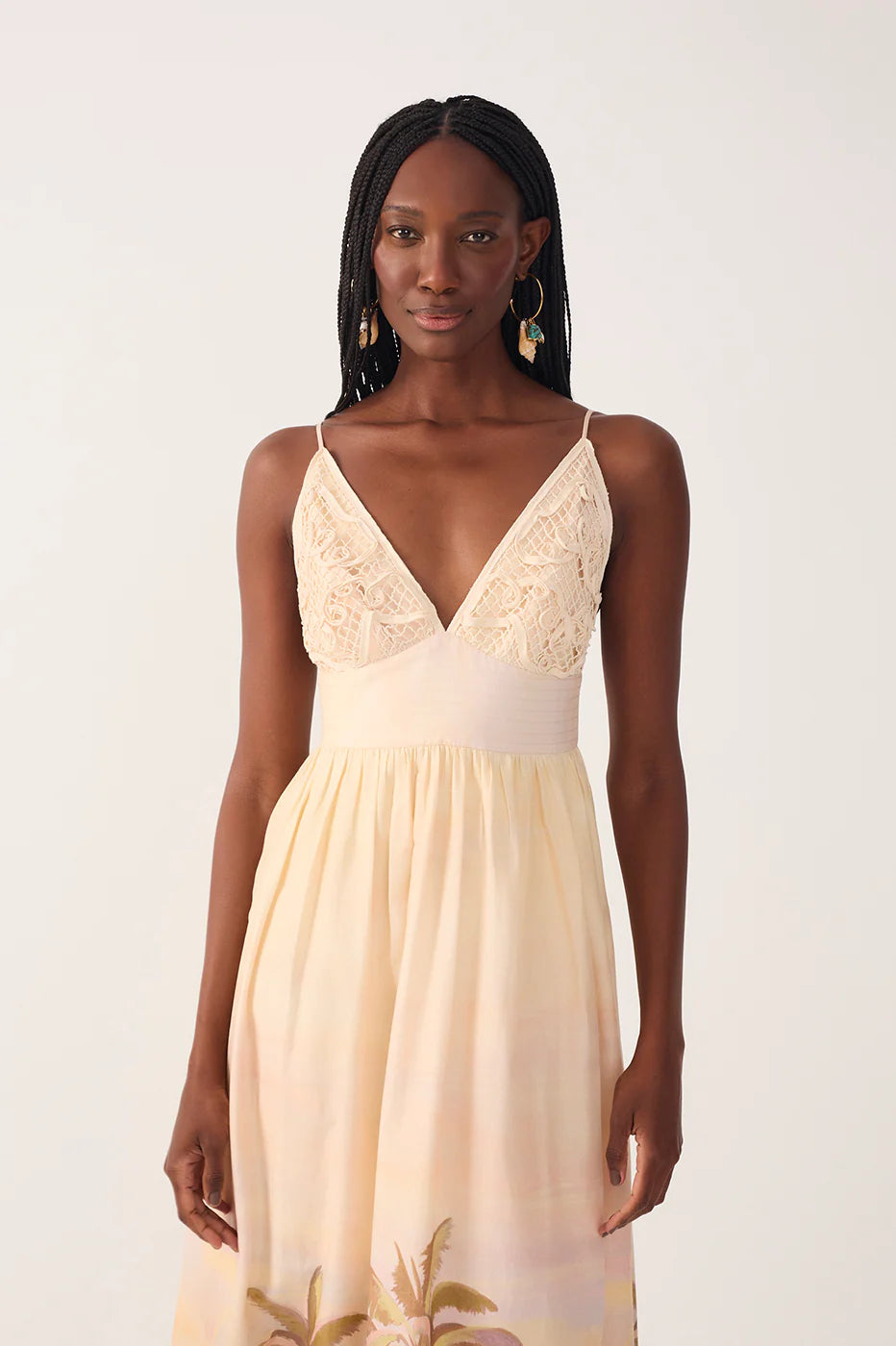 Woman wearing a beige dress with floral details on a white background