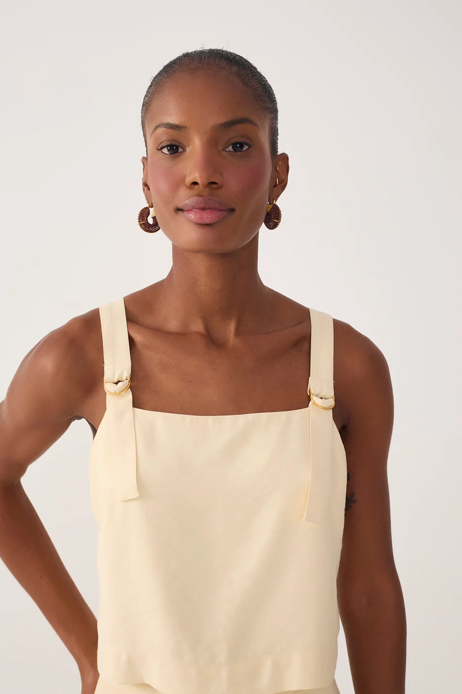 Woman wearing a beige apron against a plain background