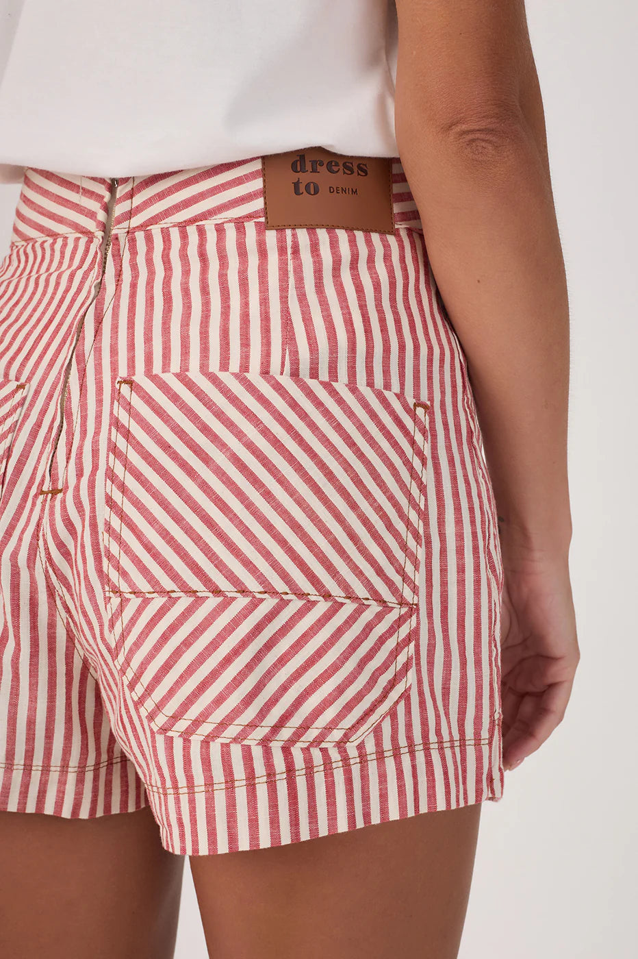Red and white striped shorts worn by a person on a white background