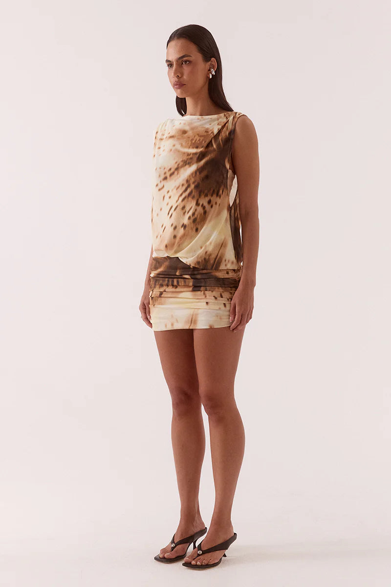 Woman wearing a sleeveless dress with a pattern on a white background