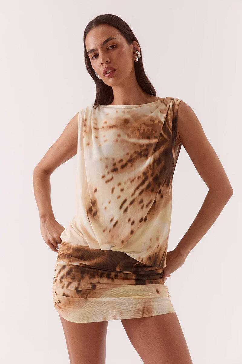 Woman wearing a tie-dye dress with a neutral background