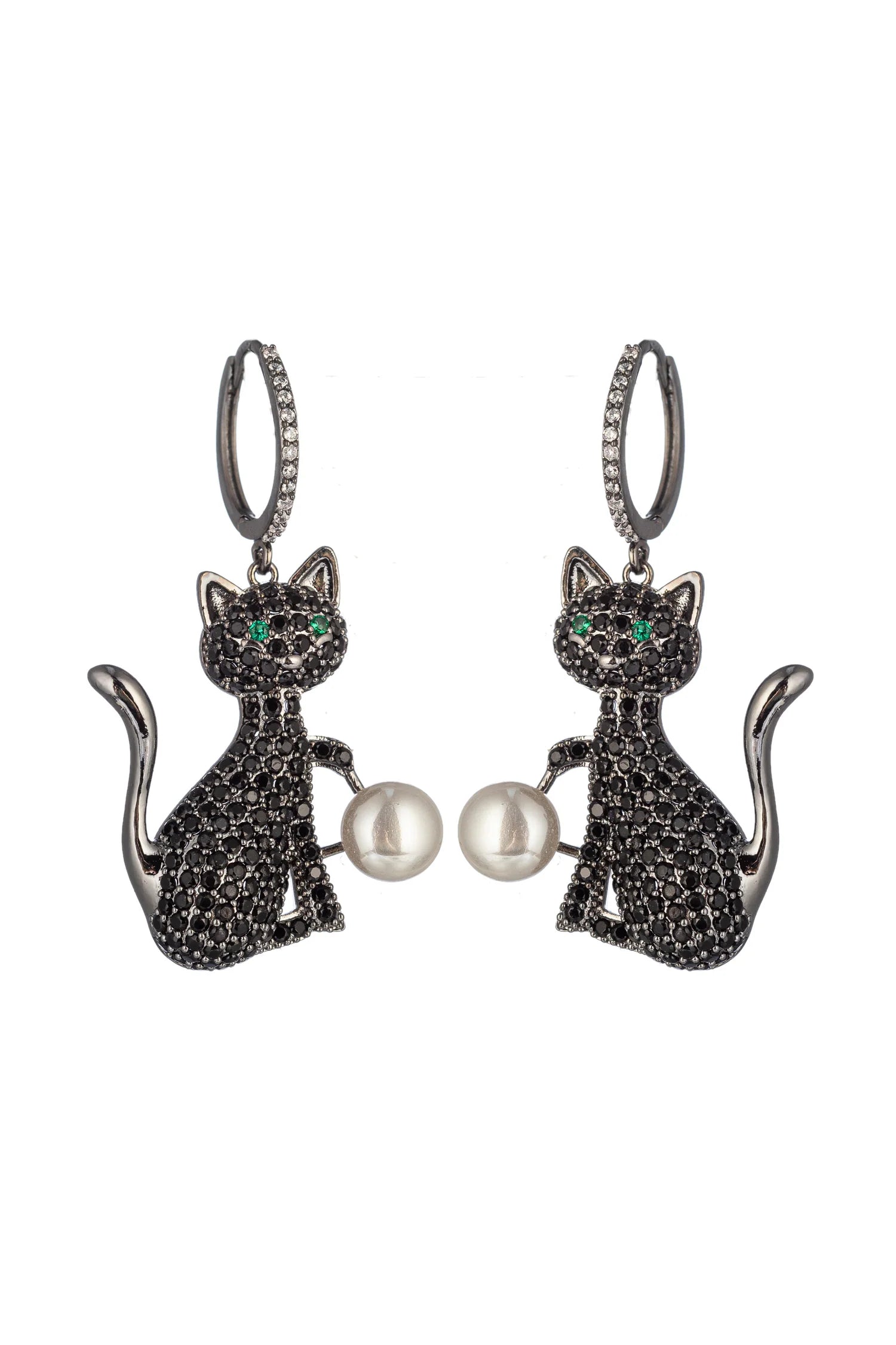 A pair of silver-tone dangle earrings shaped like sitting cats, covered in small black pavé stones, with green eye details and a white pearl held between the cats, on a plain white background.