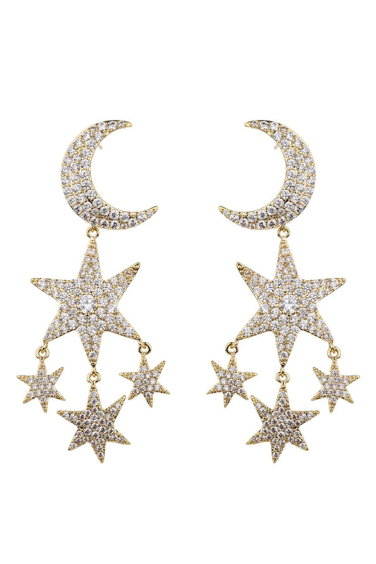 A pair of gold-toned dangle earrings featuring crescent moon and star motifs, heavily embellished with clear pavé stones, set against a plain white background.
