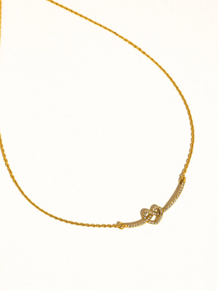 Gold heart necklace on a white background