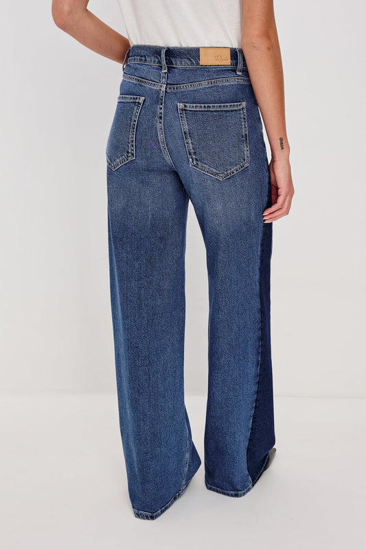 Blue wide leg jeans worn by a person on a white background