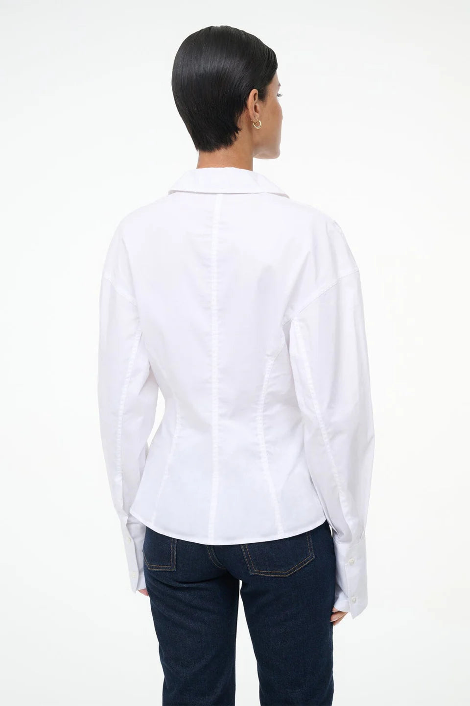Person wearing a white shirt and dark jeans on a white background