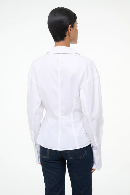 Person wearing a white shirt and dark jeans on a white background