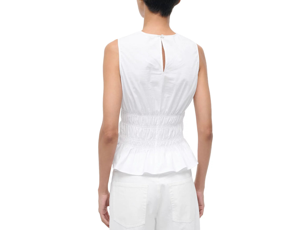 Person wearing a white sleeveless top and pants on a white background