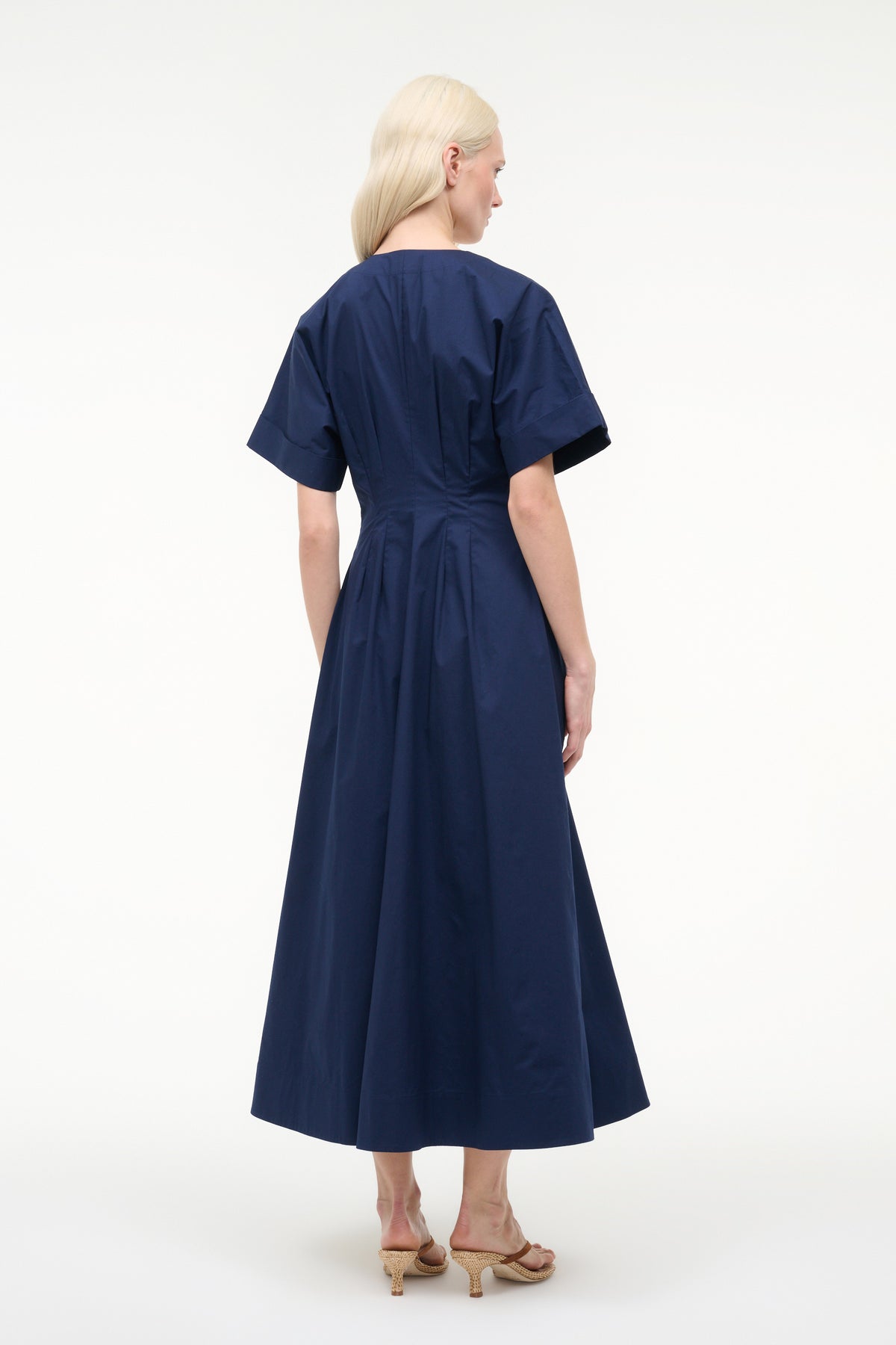 Woman wearing a navy blue dress on a white background