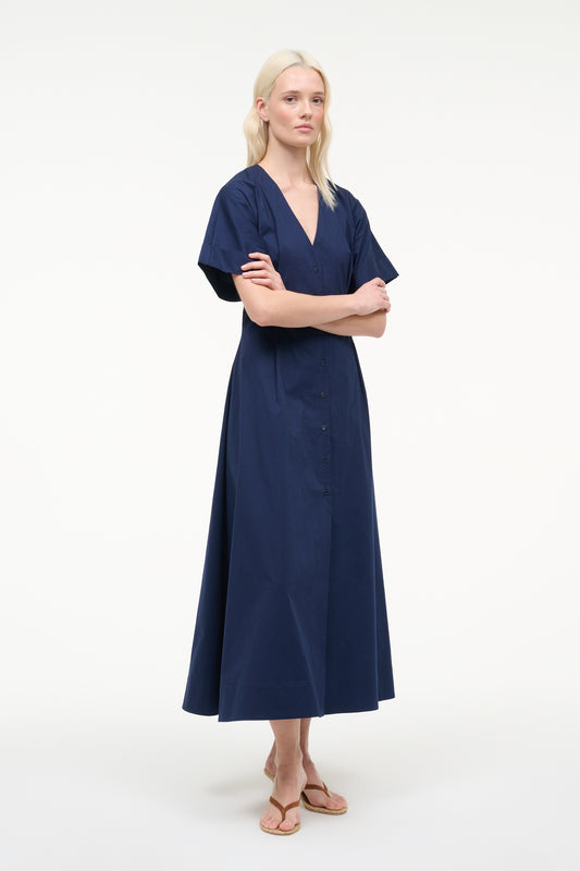 Woman wearing a navy blue dress on a white background