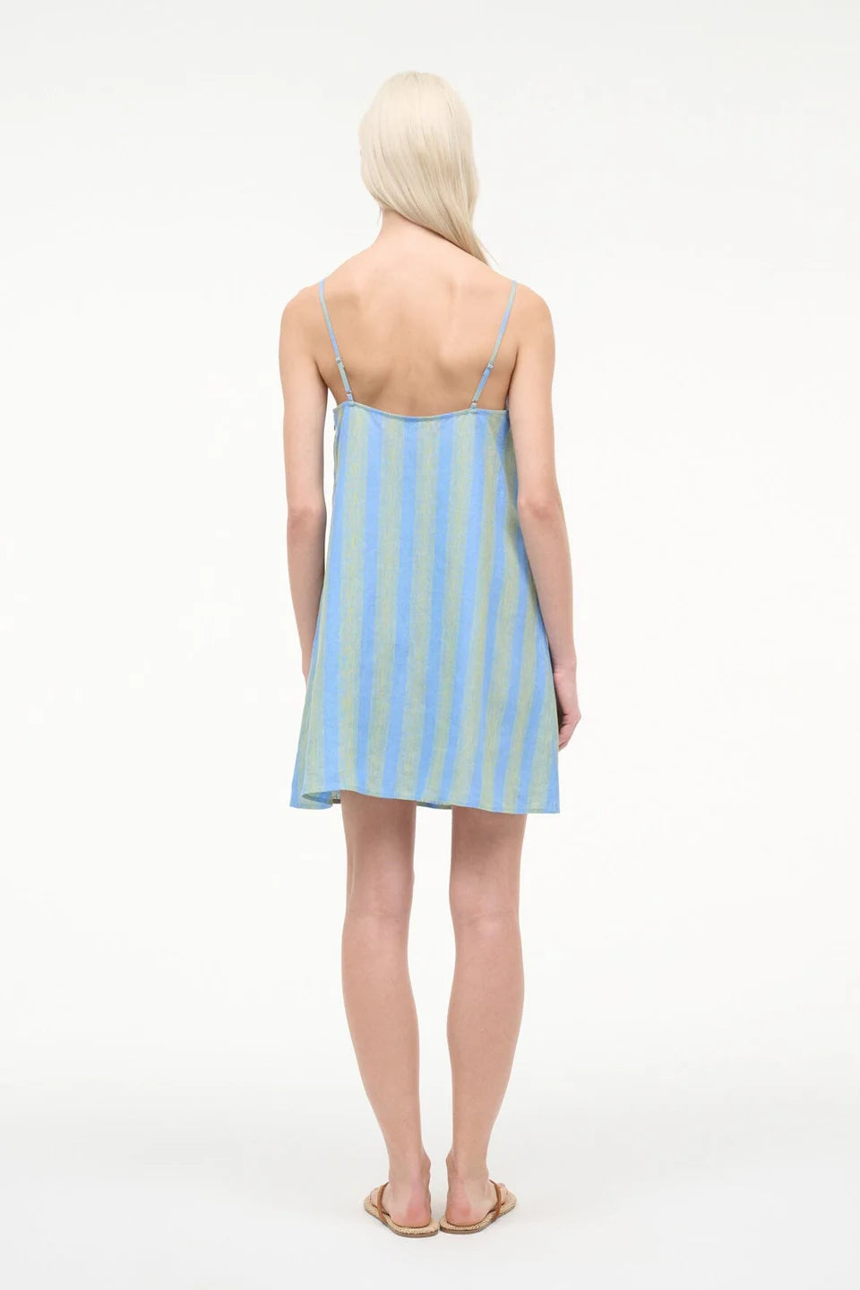 Woman wearing a light blue and white striped dress on a white background