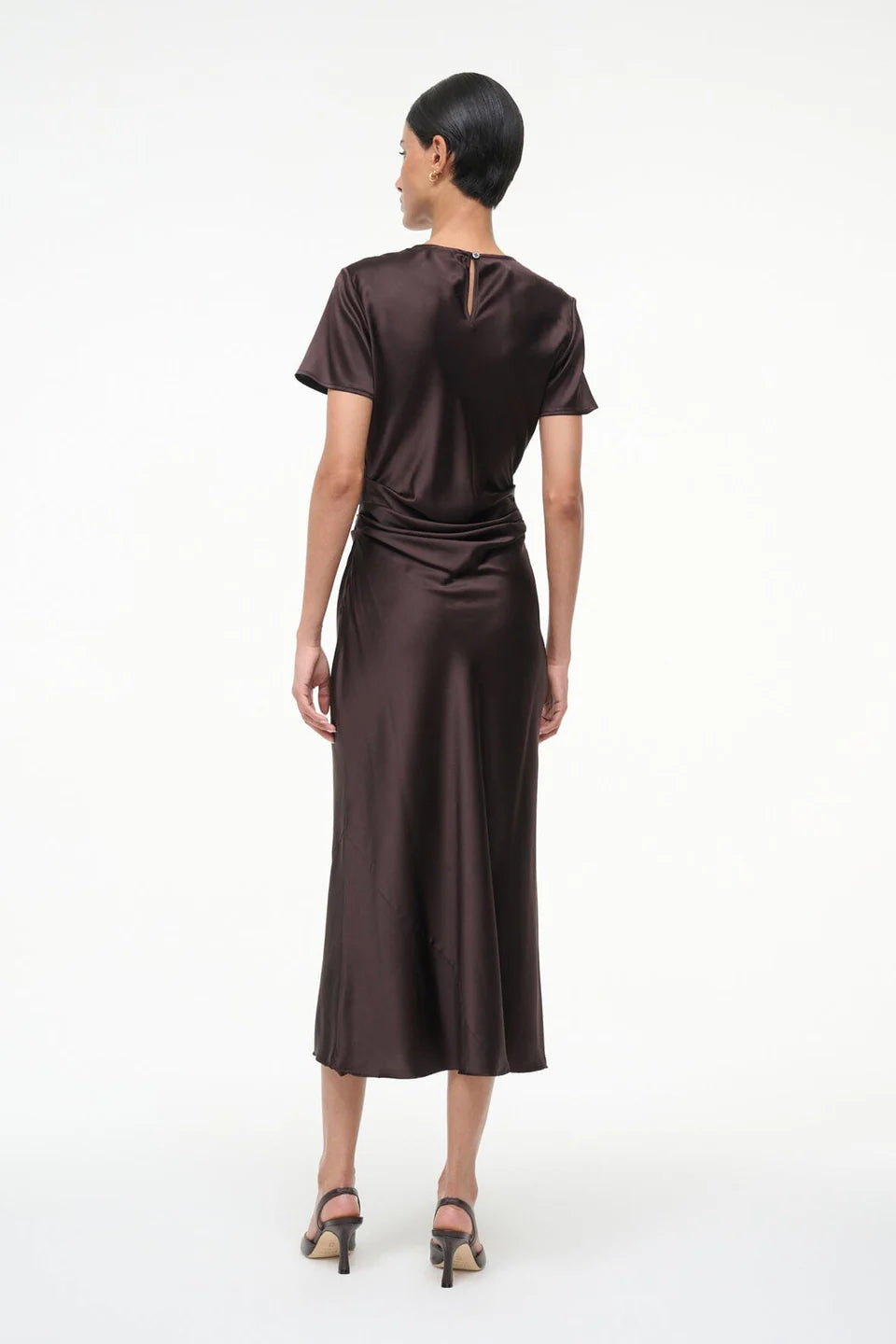 Woman wearing a brown satin dress on a white background