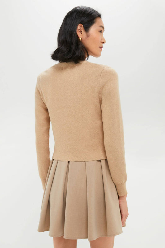 Woman wearing a beige sweater and skirt set on a white background