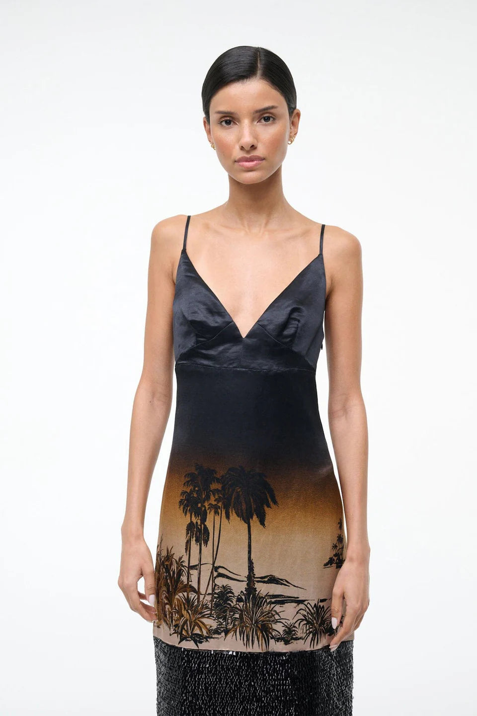 Woman wearing a black dress with a palm tree design on a white background
