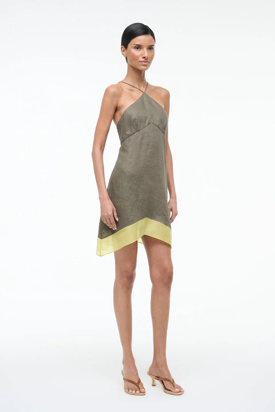 Woman wearing a green and yellow dress on a white background
