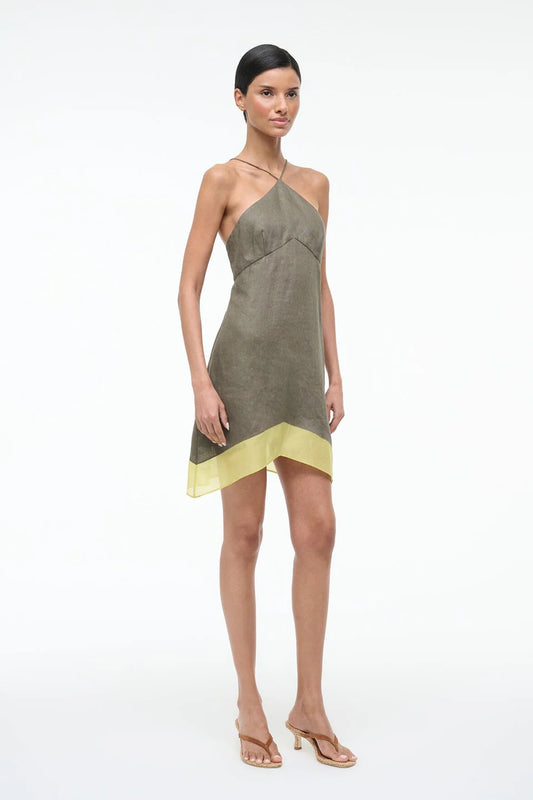 Woman wearing a green and yellow dress on a white background