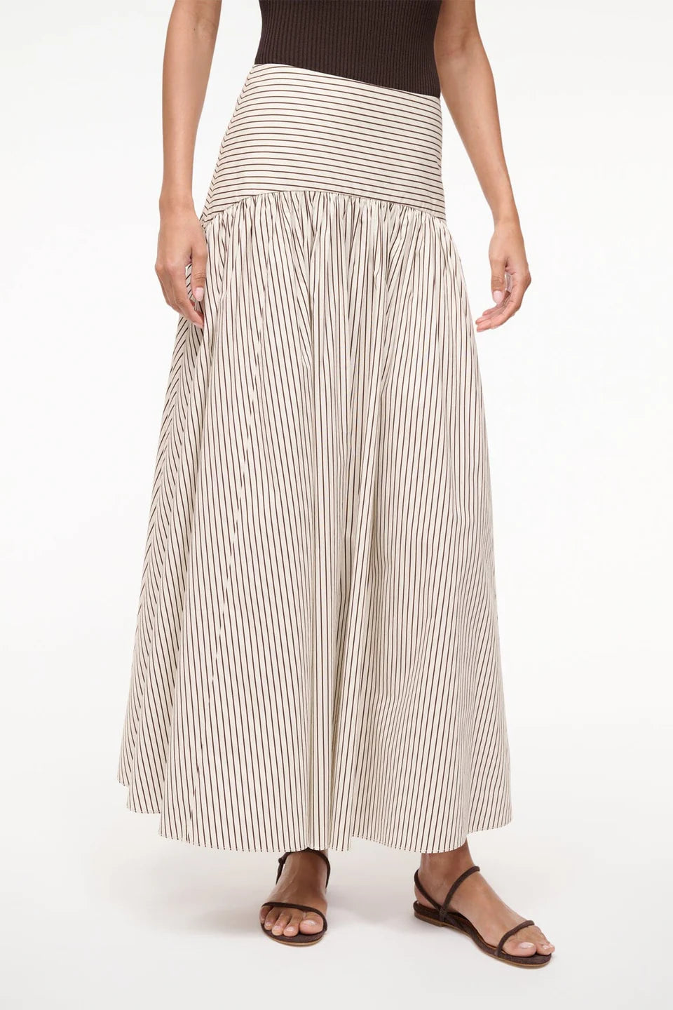 Woman wearing a long striped skirt on a white background