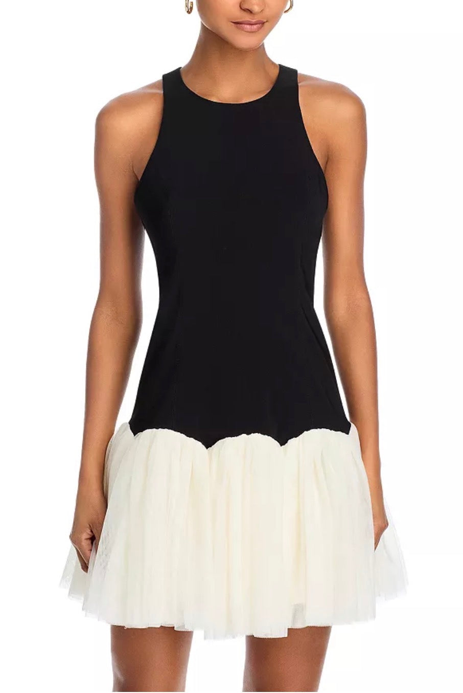 Black sleeveless dress with a white ruffled skirt on a model against a white background