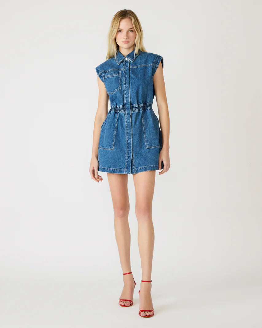 Woman wearing a denim sleeveless mini dress on a white background