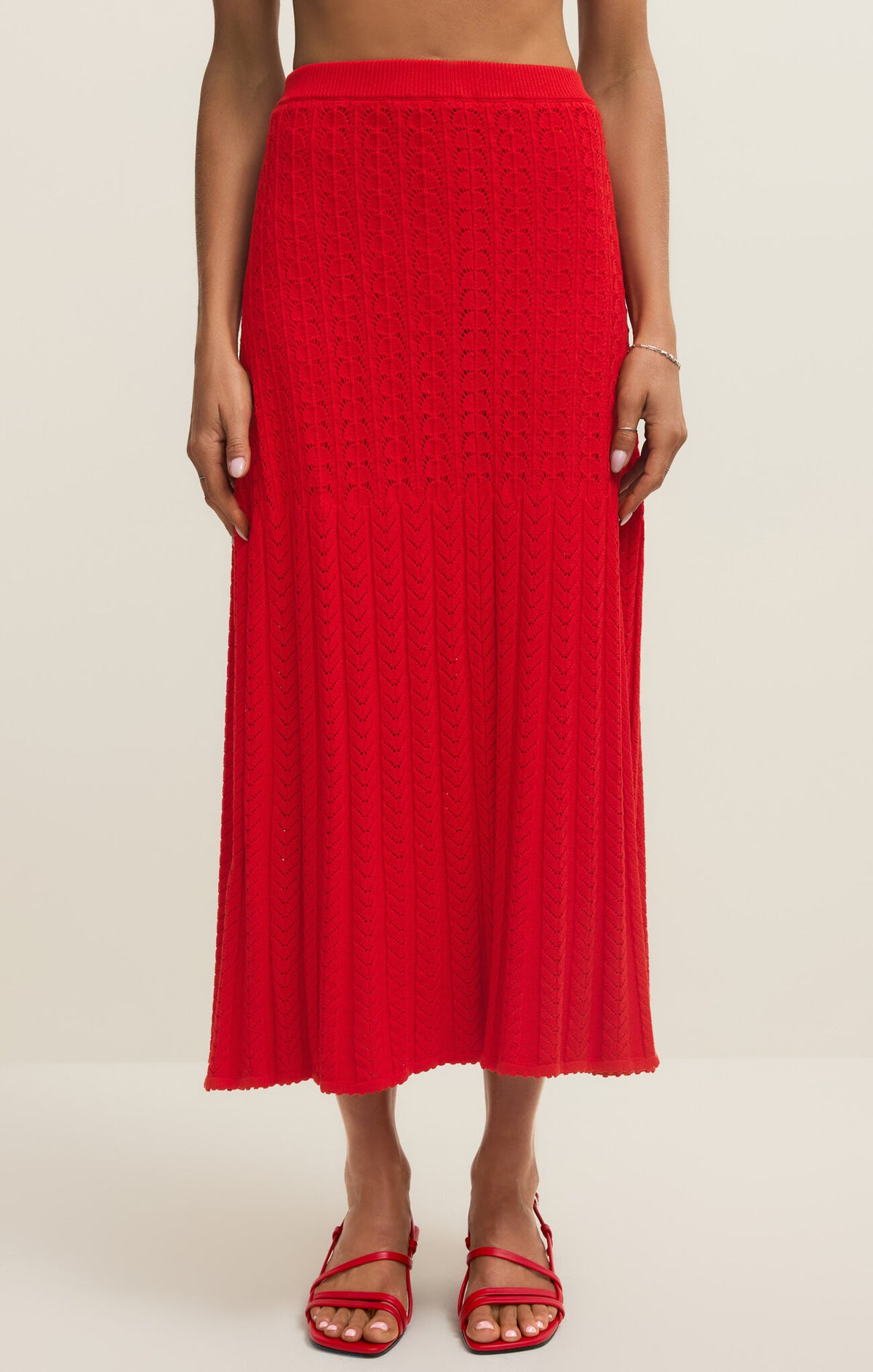 Red textured midi sweater skirt worn by a person on a beige background