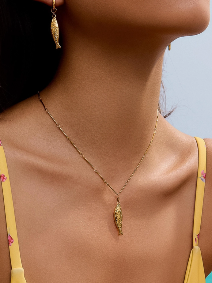 Close-up of Coralie yellow 18K gold-plated fish pendant necklace on delicate chain