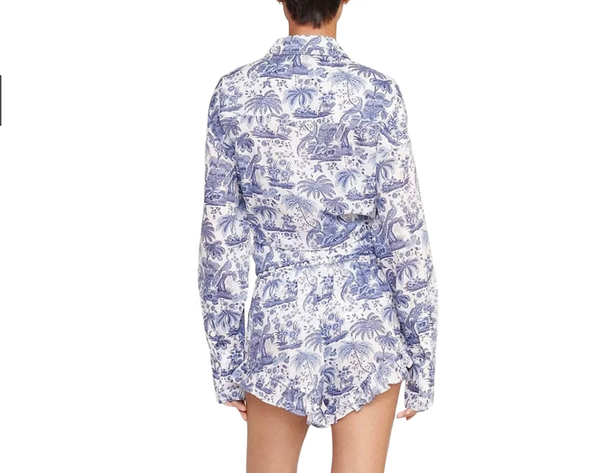 Person wearing a white shirt with blue floral pattern on a white background