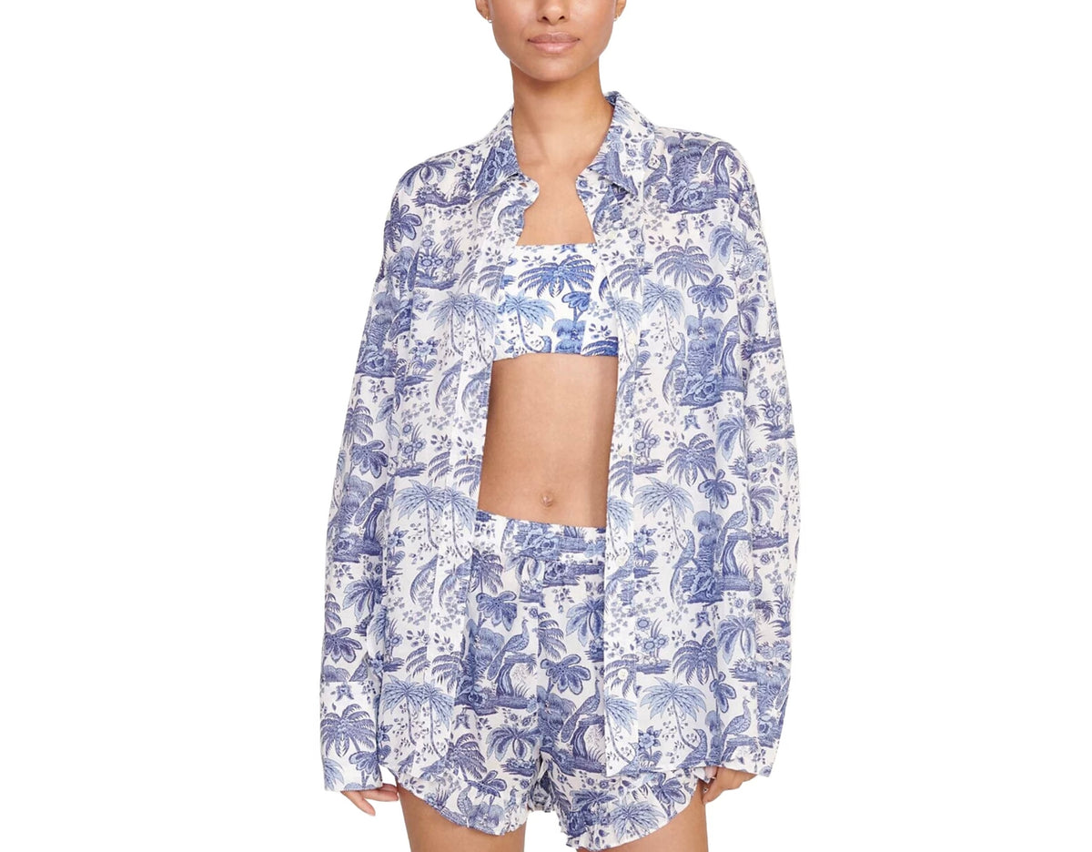 Woman wearing a blue and white floral pajama set on a white background