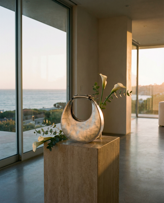 Decorative vase on a pedestal with flowers in a modern room with large windows overlooking a scenic view.